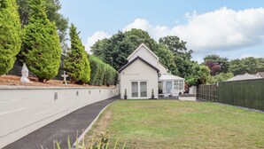 Een modern huis met een verharde oprit, een verzorgd gazon en een omheinde achtertuin.