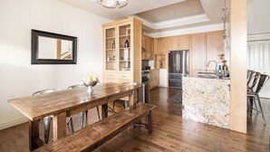 Une cuisine moderne avec des meubles en bois, un four encastré et un réfrigérateur en acier inoxydable.