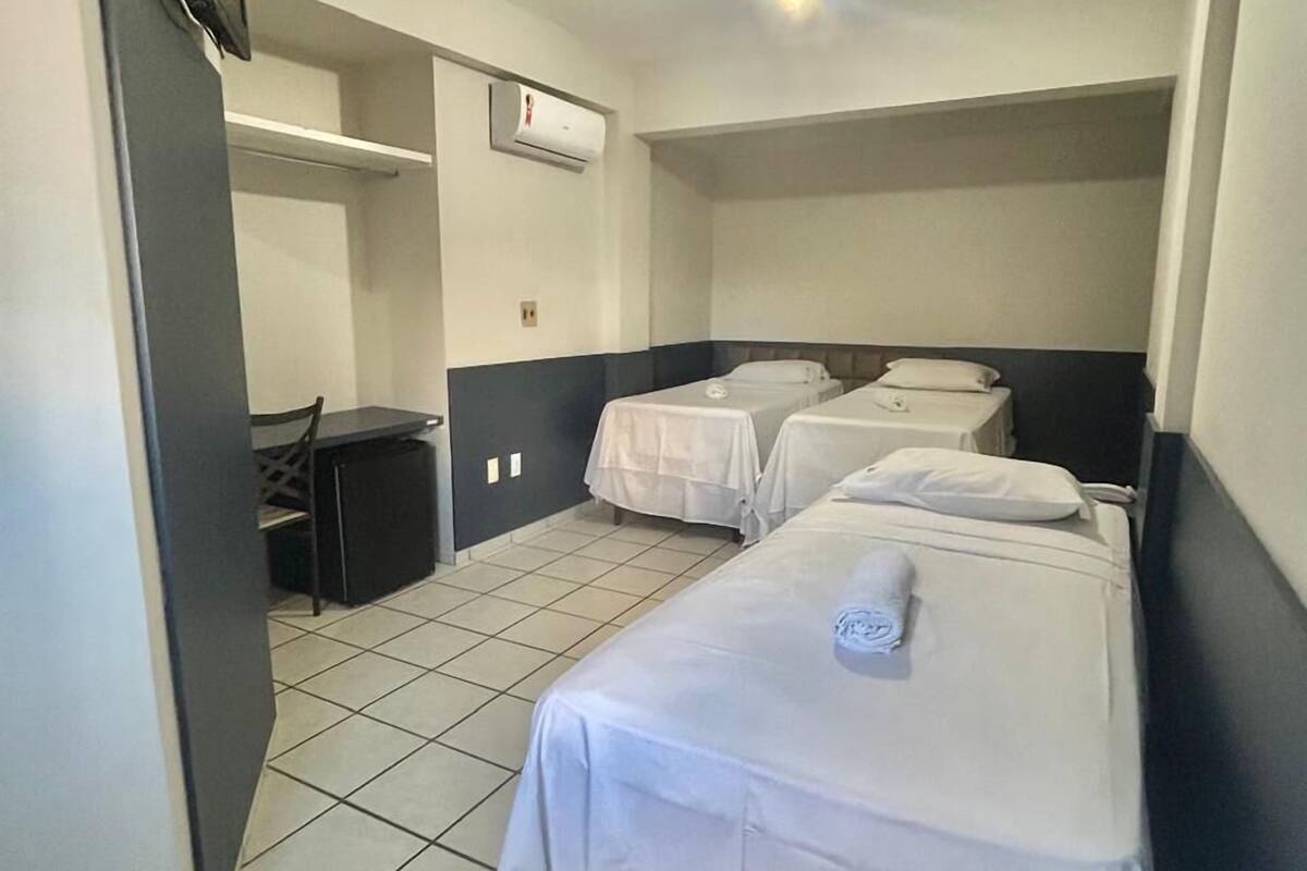 Une chambre d’hôtel avec deux lits simples, un bureau et une chaise.