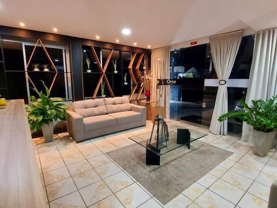 Uma sala de estar moderna com um sofá, uma mesa de centro e plantas em vasos.