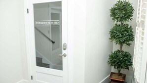 A white door with a frosted glass panel and a sign reading "POMAR HOUSE SUITES." - St. Augustine Apartment: Walk to Historic Sites! (St. Augustine)