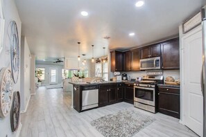A spacious kitchen with dark wood cabinets, stainless steel appliances, and a central island.