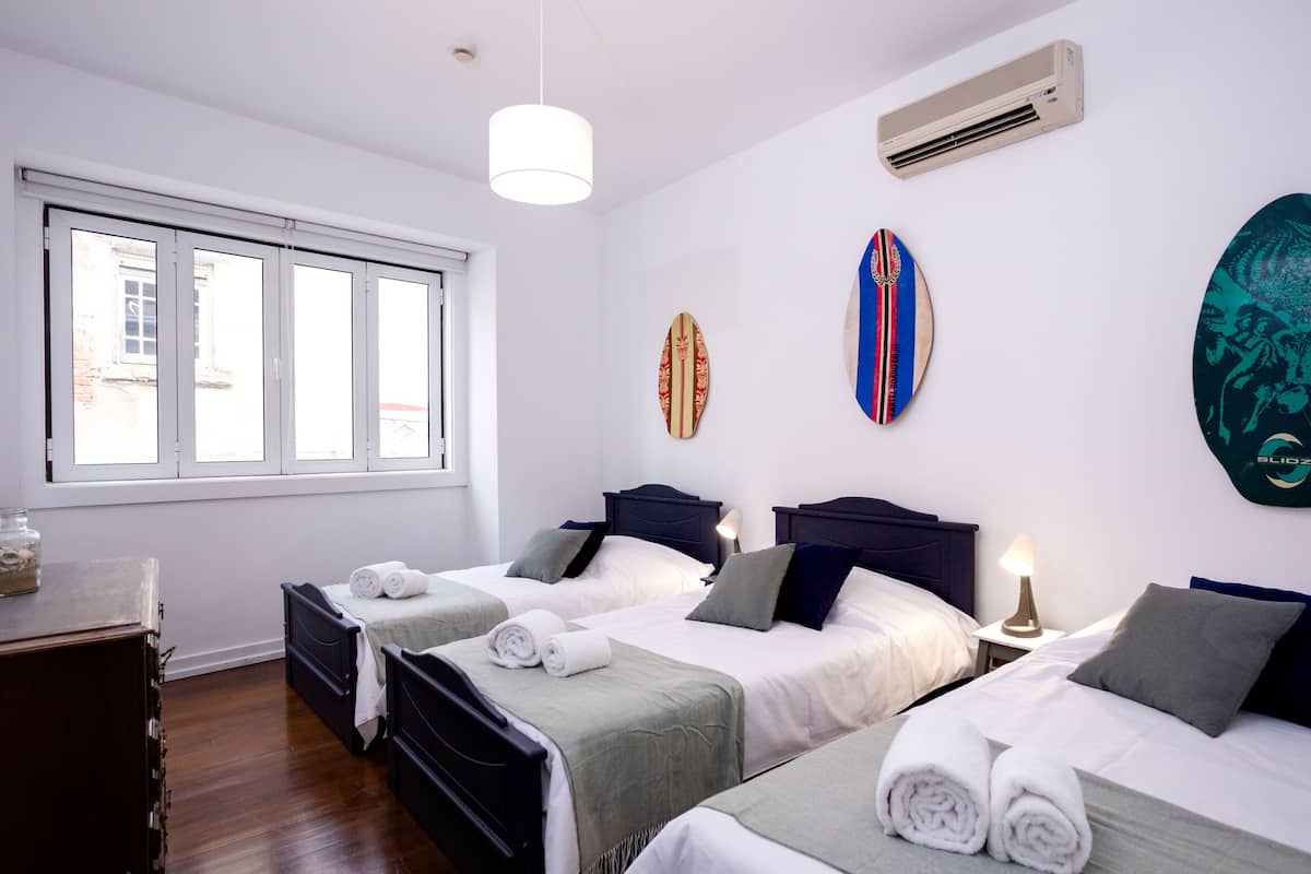 A hotel room with two beds, a window, and wall decorations.