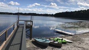 Un lac paisible, avec une jetée en bois et un bateau à rames.