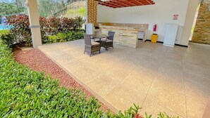 A spacious outdoor area with a reception desk, seating, and a stone wall.