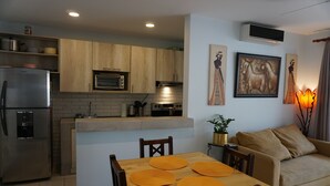 A modern kitchen with wooden cabinets, a built-in oven, and a stainless steel refrigerator.