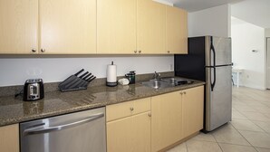 Una cucina moderna con mobili in legno, elettrodomestici in acciaio inossidabile e un piano di lavoro in granito.