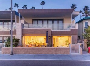 A modern two-story building with a large open entrance and a balcony. - Gorgeous Oceanside Sunsets on The Strand-Watch Waves and Dolphins (Oceanside)