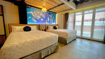 A hotel room with two beds, a large mural on the wall, and a view through the window.