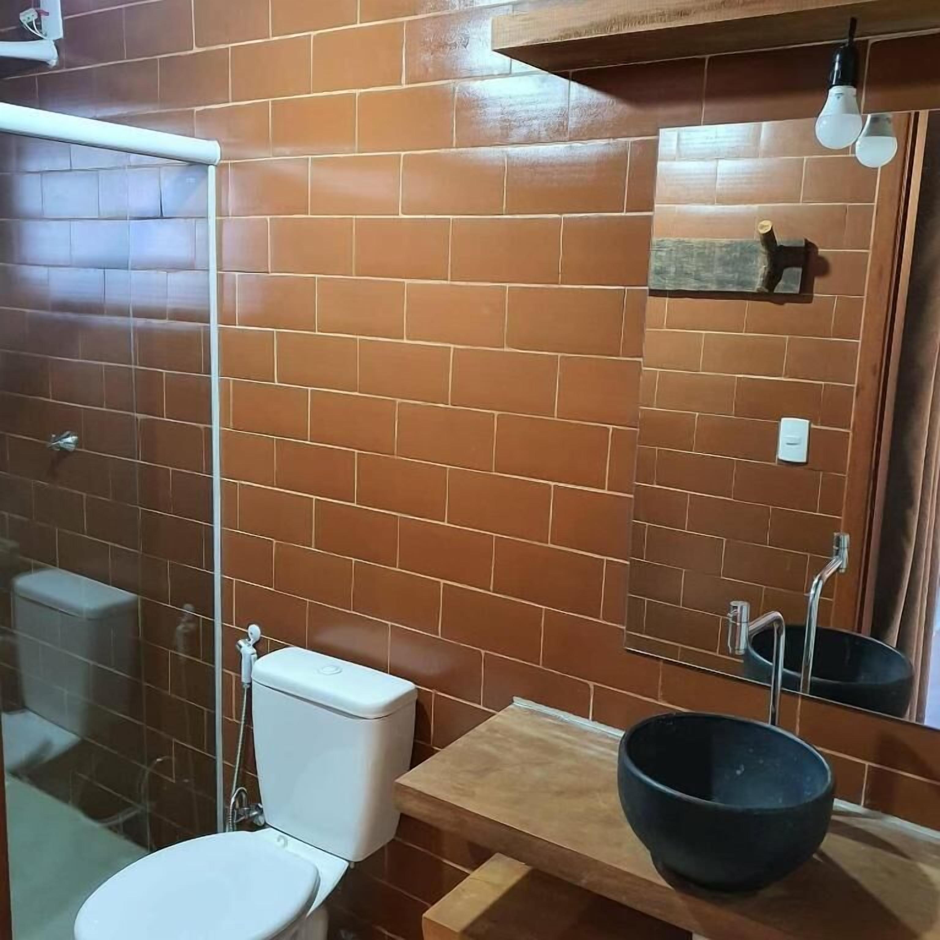 Un baño con inodoro, lavamanos y espejo.