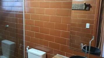 Un baño con inodoro, lavamanos y espejo.