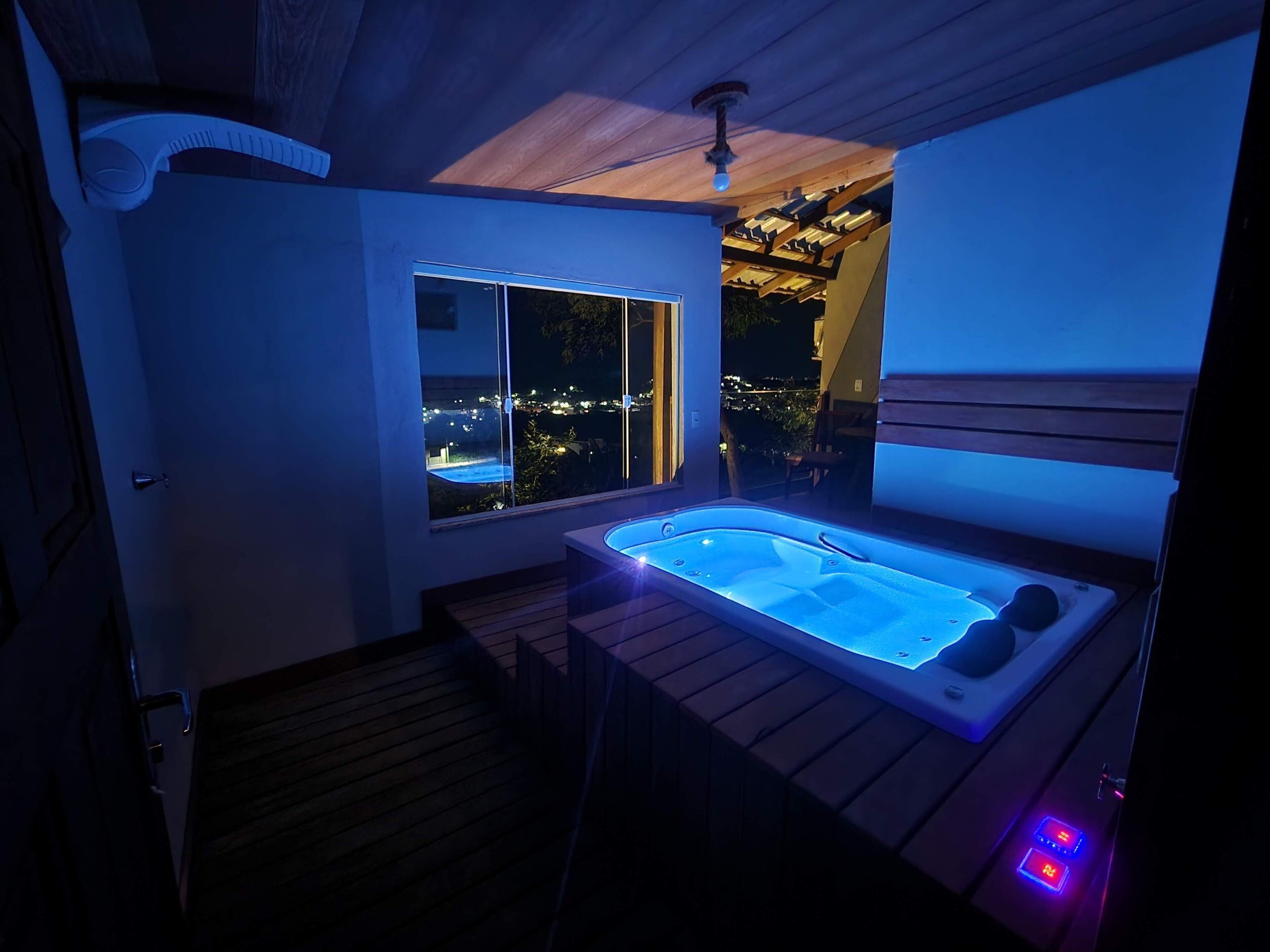 Un jacuzzi con vistas a un paisaje urbano nocturno.