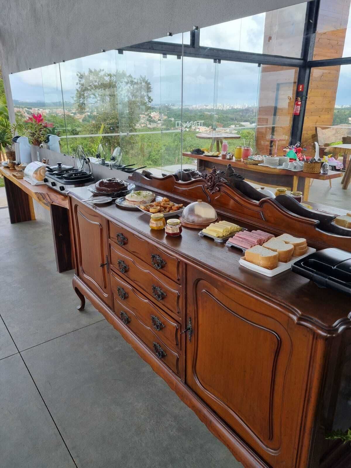 A breakfast bar with various food items and a view of a cityscape through large windows.