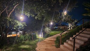 Un camino bien iluminado que lleva a un edificio con un letrero que indica un restaurante.