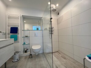 Een douche, een haardroger, handdoeken, toiletpapier