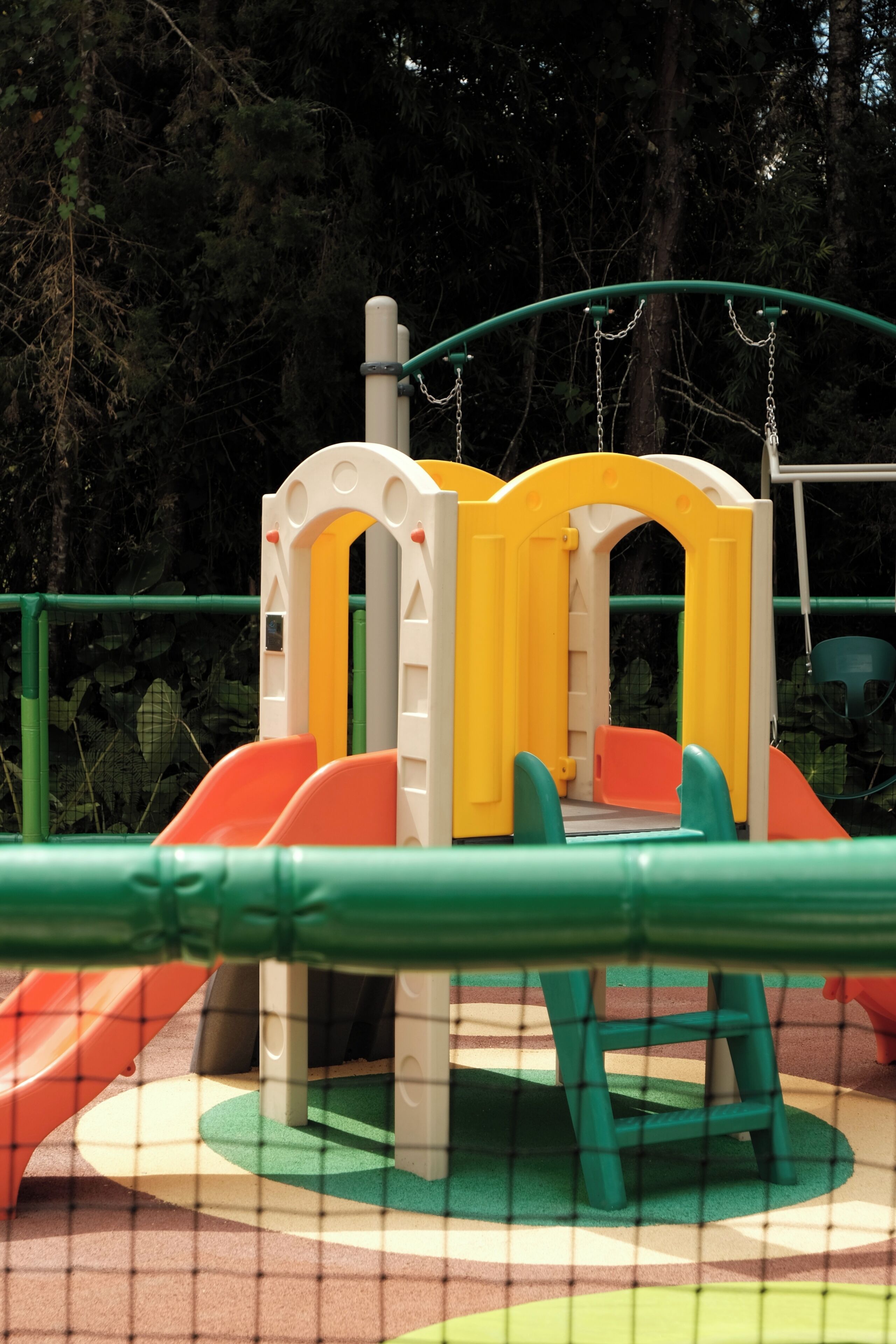 Un parque infantil con una estructura para escalar y toboganes.