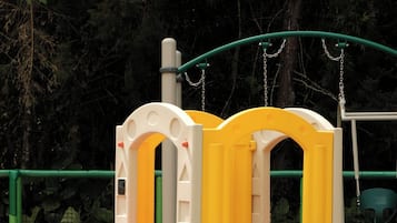 Un parque infantil con una estructura para escalar y toboganes.