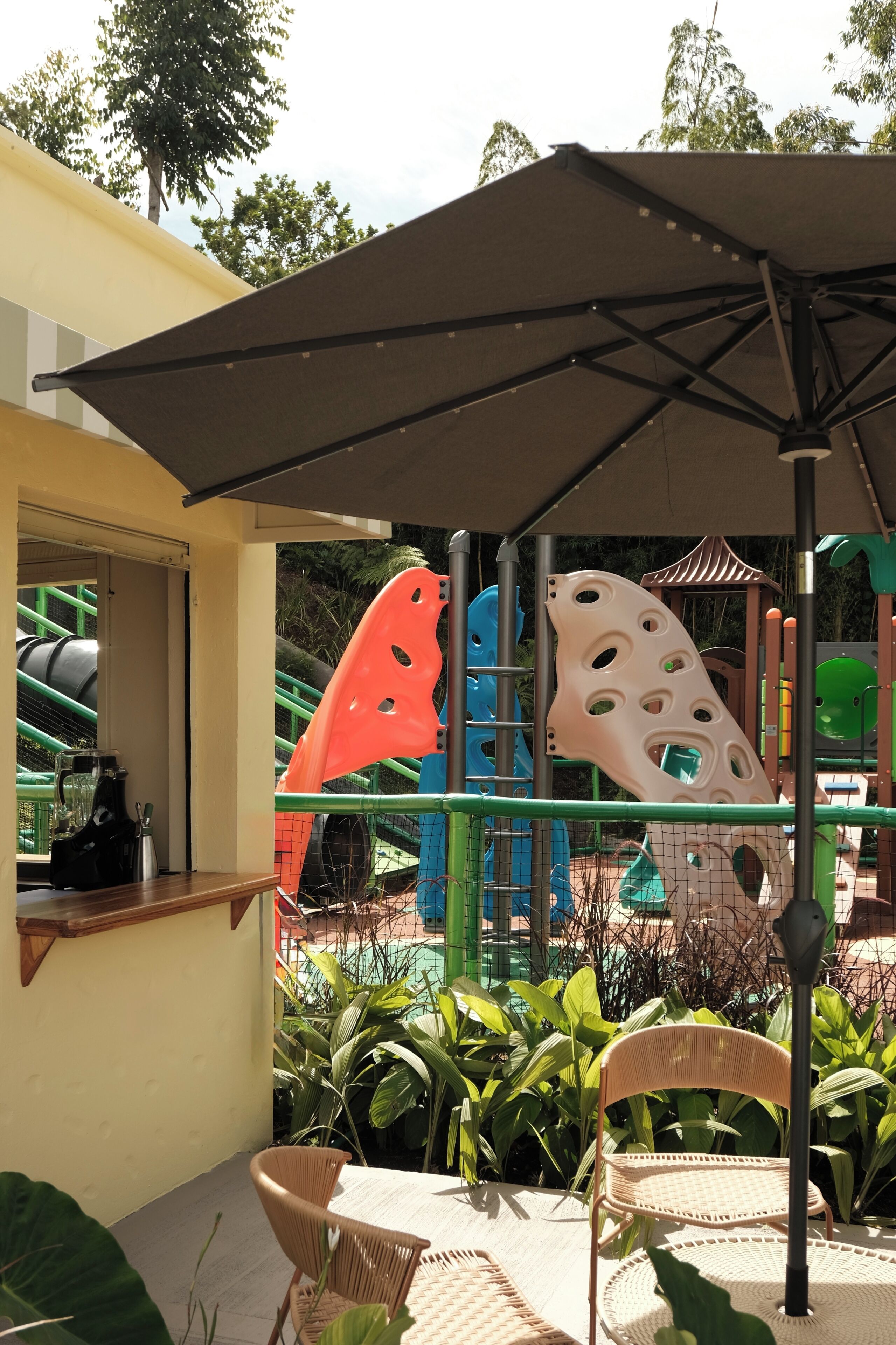 An outdoor seating area with a table, chairs, and a shaded umbrella.