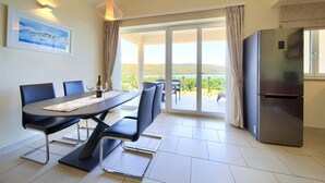 Un comedor con mesa, sillas y vistas al exterior.