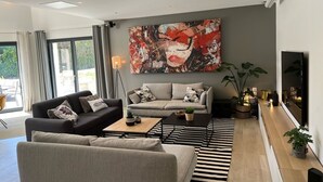 A modern living room with a sofa, a coffee table, and a large abstract painting on the wall.