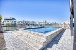 Enjoy a refreshing swim in the pool surrounded by a deck and steps leading to the water's edge.