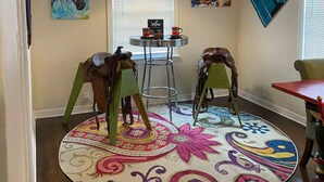 A room with a round carpet, two chairs, a table, and artwork on the walls. - Horsefeathers 🐾 pet friendly funky comfort (Amarillo)