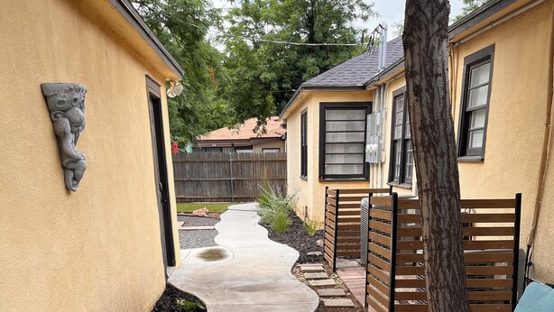 A concrete pathway leading to a wooden fence and a bench. - Horsefeathers 🐾 pet friendly funky comfort (Amarillo)