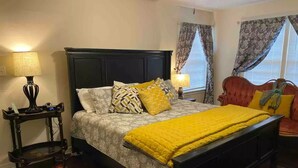 A bedroom with a bed, bedside tables, a nightstand, a window with curtains, and a red armchair. - Horsefeathers 🐾 pet friendly funky comfort (Amarillo)
