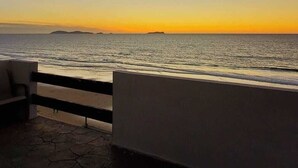 Un balcón con vista al mar al atardecer.