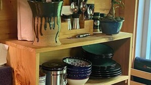 A kitchen with wooden shelves, a plant, and various kitchen utensils. - Dreamy Treehouse Getaway ~Dog Friendly~Disc Golf (Copperhill)