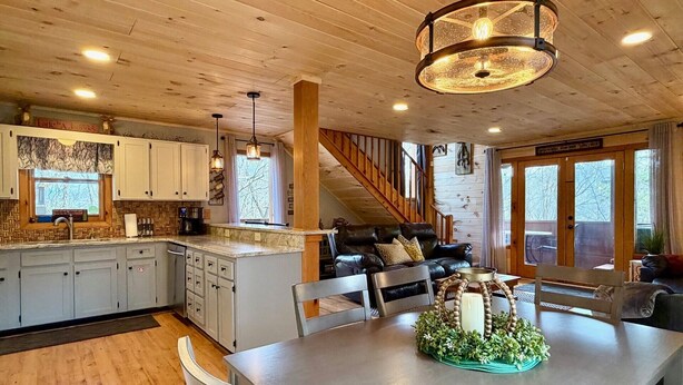 A spacious kitchen with wooden cabinets, a large island, and a dining area with a table and chairs.