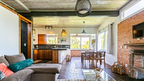 Una sala de estar moderna con un sofá modular, una mesa de centro de vidrio y una chimenea.