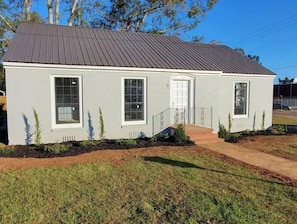 Simple, single-story home with a flat roof and a cozy front porch.