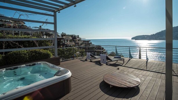 A rooftop terrace with a hot tub, lounge chairs, and a view of the sea. - Dukley Penthouse 3 Bedrooms (Budva)