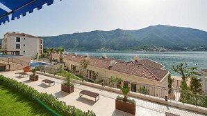 Un hôtel situé sur la côte, doté d’une piscine, d’un espace extérieur aménagé et offrant une vue sur les montagnes.