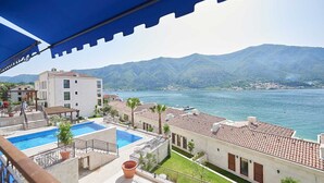 Un hotel con piscina, terraza y vistas a la montaña.