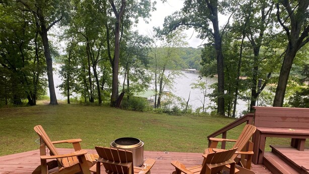 A wooden deck with Adirondack chairs and a fire pit overlooking a lake. - Beaver Lake Paradise with Bunkhouse (Springdale)
