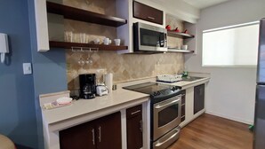 Una cocina moderna con electrodomésticos de acero inoxidable, armarios de madera y un ventanal que proporciona luz natural.