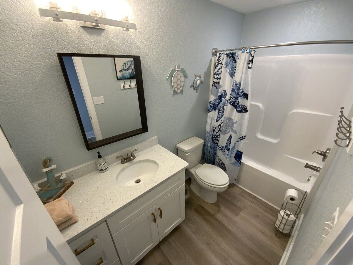 A bathroom with a sink, toilet, and bathtub.