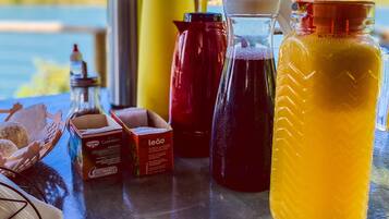 A table with various containers and a box of Leão brand products, set against a scenic outdoor backdrop.