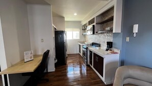 A compact kitchen with a dining area, wooden flooring, and built-in cabinets. - Spacious 2 bedroom apartment by the bullring (Tijuana)