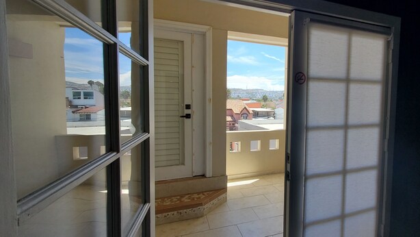 A view from a balcony with a door leading outside. - Spacious 2 bedroom apartment by the bullring (Tijuana)