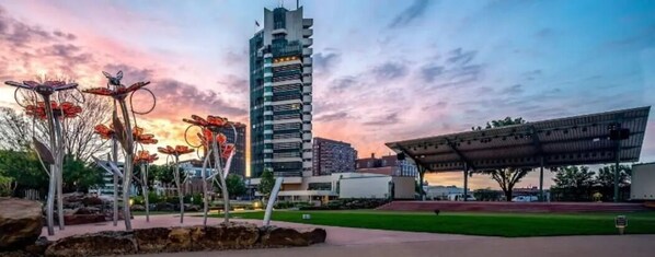 A modern building with a unique architectural design, surrounded by a landscaped area with metal sculptures.