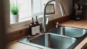 A kitchen with a stainless steel sink, wooden countertop, and a potted plant on the windowsill. - Harte Of The Pines Pet Friendly Walk to Downtown (Twain Harte)