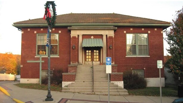 A brick building with a green awning, a front entrance, and a sign indicating a public library. - In the Heart of Historic Paoli (Paoli)