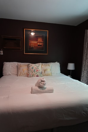 A hotel room with a neatly made bed, a framed artwork above the bed, and a lamp on the side. - Poconos Top Rated Resort - Saw Creek Estates (Bushkill)