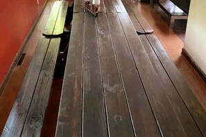 A wooden bench with a metal frame, a wooden table, and a bench in a hallway. - Poconos Top Rated Resort - Saw Creek Estates (Bushkill)