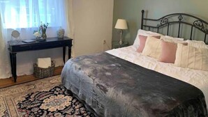 A bedroom with a bed, a nightstand, a desk, and a window with curtains. - Lancaster Musically Inspired Home Downtown Sleeps6 (Lancaster)