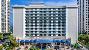 A multi-story hotel with a central atrium, a covered parking area, and a view of the surrounding high-rise buildings. - Oceanfront renovated condo on the beach - amazing ocean view (Sunny Isles Beach)