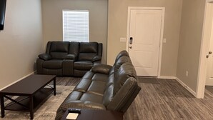 Una sala de estar con un sofá seccional, una mesa de centro y una puerta.